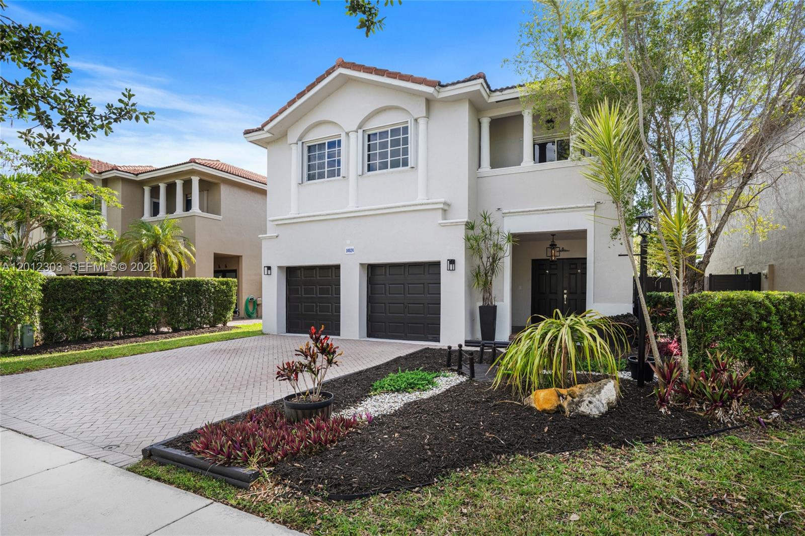 A two-story house with a two-car garage, white stucco exterior, and a landscaped front yard — 14024 SW 132nd Ave, Miami FL 33186, MIAMI, FL
