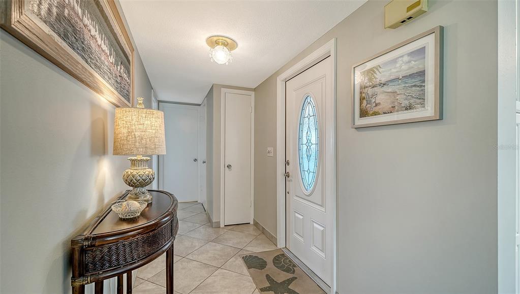 A bright entryway features tile flooring, a console table with a lamp, and a front door — 2657 RIVERBLUFF PARKWAY UNIT V122, SARASOTA, FL