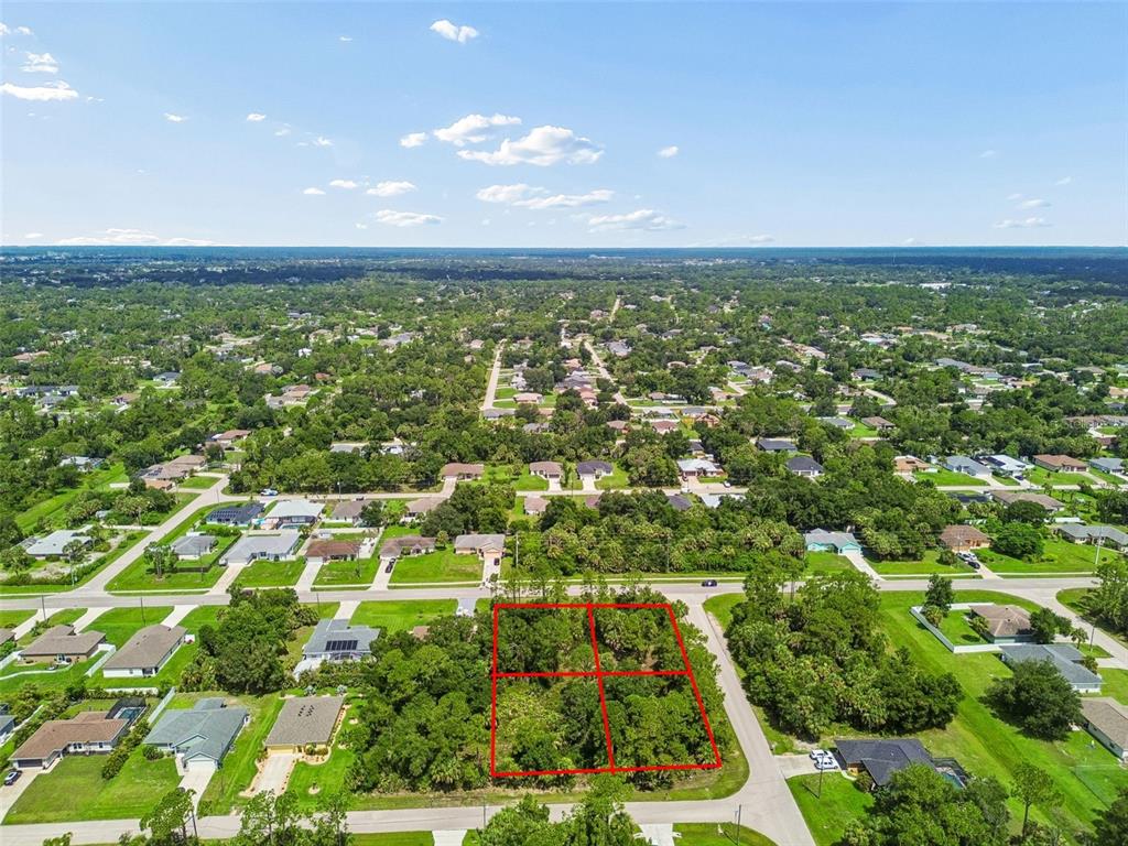 An aerial view shows four adjacent vacant lots outlined in red within a residential neighborhood — 13 S CHAMBERLAIN BOULEVARD, NORTH PORT, FL