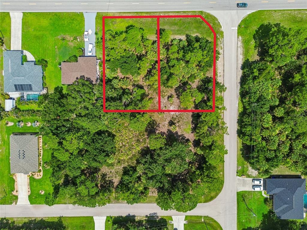 An aerial view shows two adjacent, wooded vacant lots outlined in red on a corner — 13 S CHAMBERLAIN BOULEVARD, NORTH PORT, FL