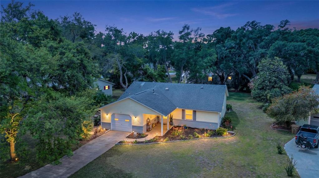 An aerial view of a single-story house with a light yellow exterior and attached garage — 27 GORDON COURT, LEESBURG, FL