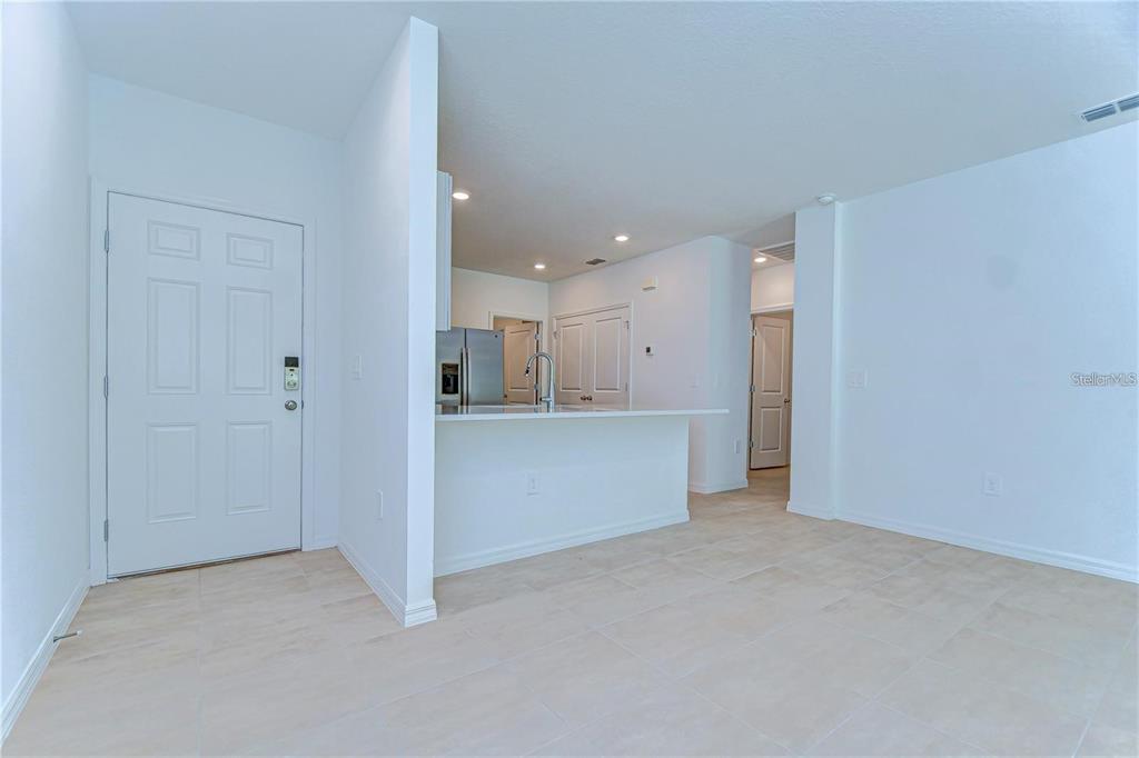 An open-concept living area features a kitchen with a breakfast bar and tile flooring — 13341 TROPICAL BREEZE WAY, HUDSON, FL