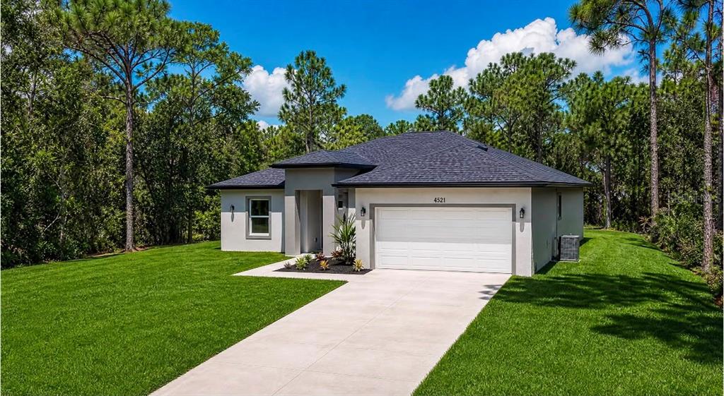 An open-concept kitchen and living area features light wood flooring, white cabinetry, and an island — 8413 SW 131ST LANE, OCALA, FL