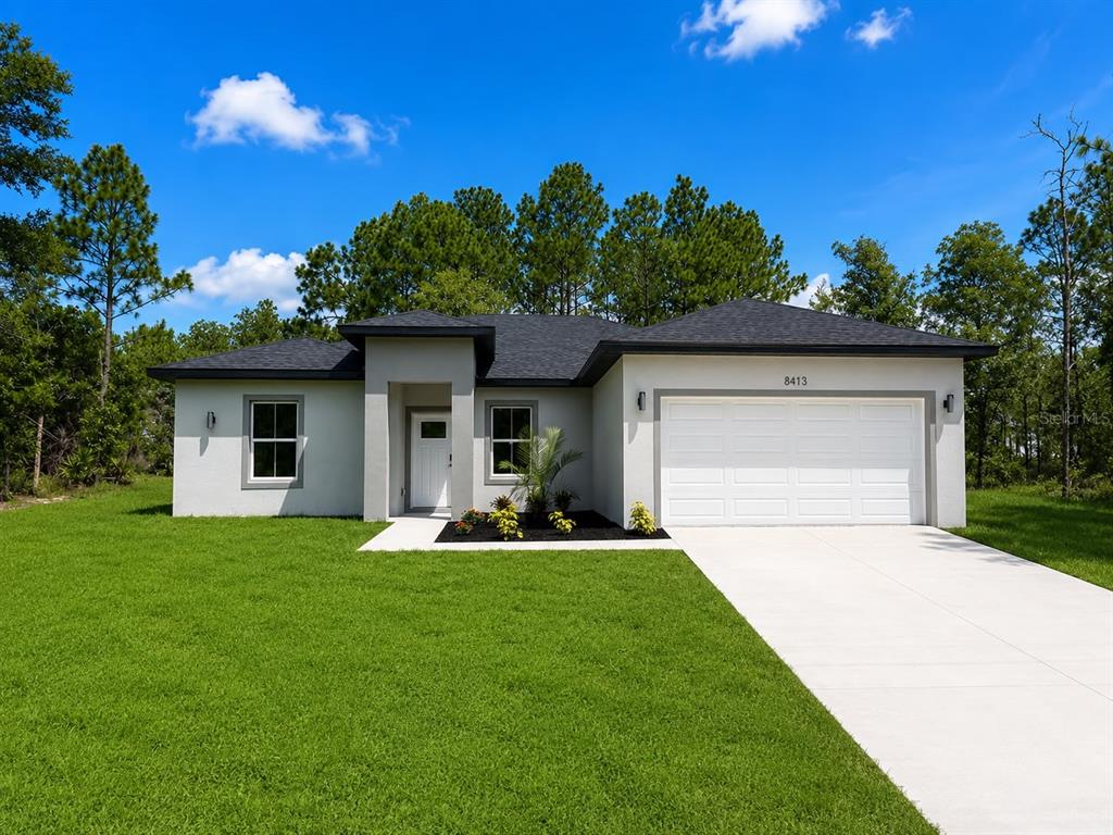 A modern kitchen features white cabinetry, stainless steel appliances, and a central island — 8413 SW 131ST LANE, OCALA, FL