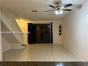 An open living area features tile flooring, a staircase with white railings, and a ceiling fan — 3907 Tree Top Dr # 3907, Weston FL 33332, WESTON, FL