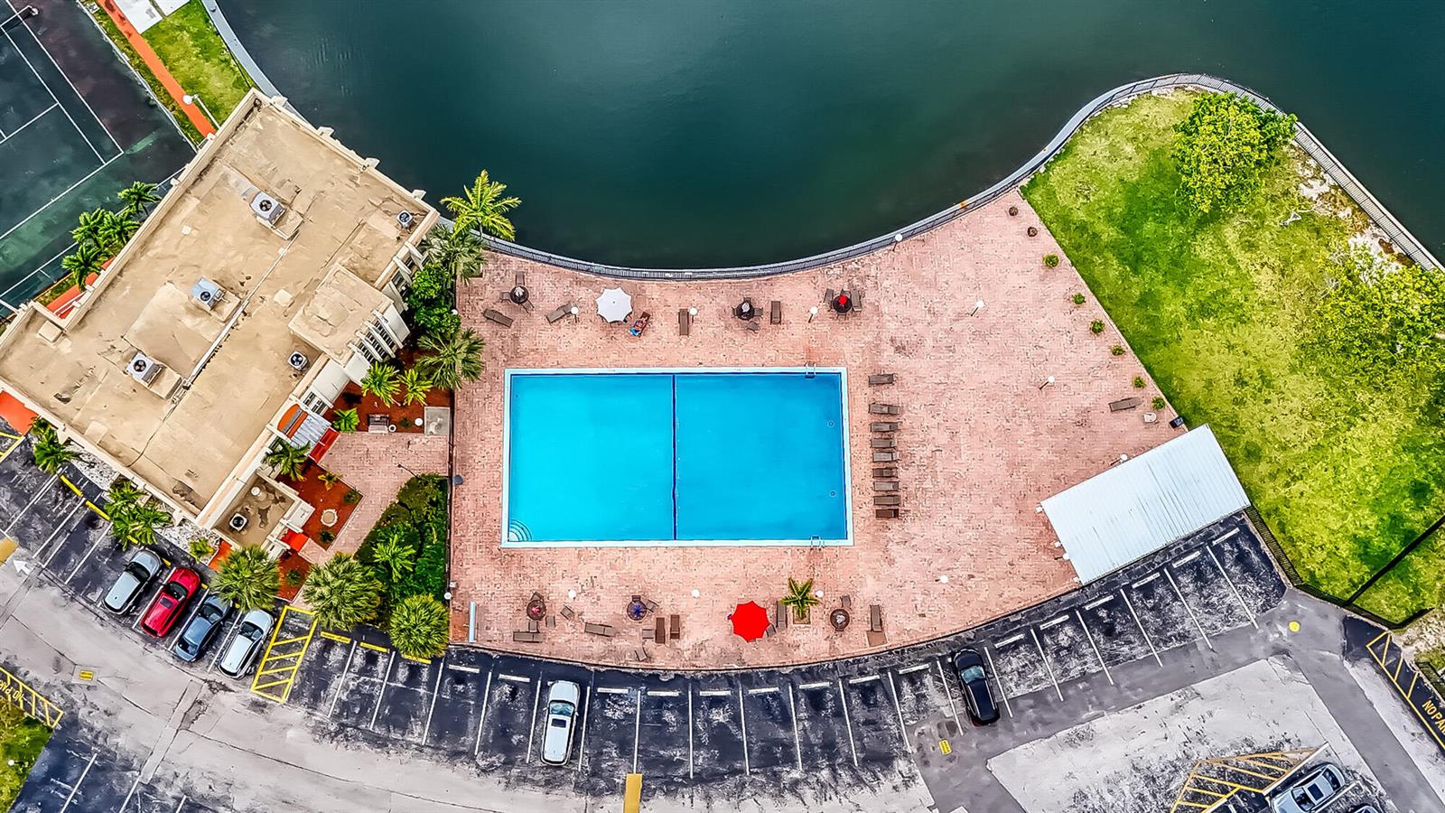 An aerial view shows a rectangular swimming pool on a brick patio beside a building — 2000 Atlantic Shores Boulevard # 410, Hallandale Beach FL 33009, HALLANDALE BEACH, FL