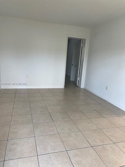 An empty room features light-colored floor tiles and a doorway leading to another space — 6780 SW 44th St # 2, Miami FL 33155, MIAMI, FL