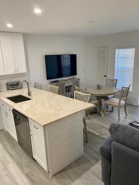 A kitchen with a light-colored island, white cabinets, and an adjacent dining area — 1605 S Us Highway 1 # 106, Jupiter FL 33477, JUPITER, FL