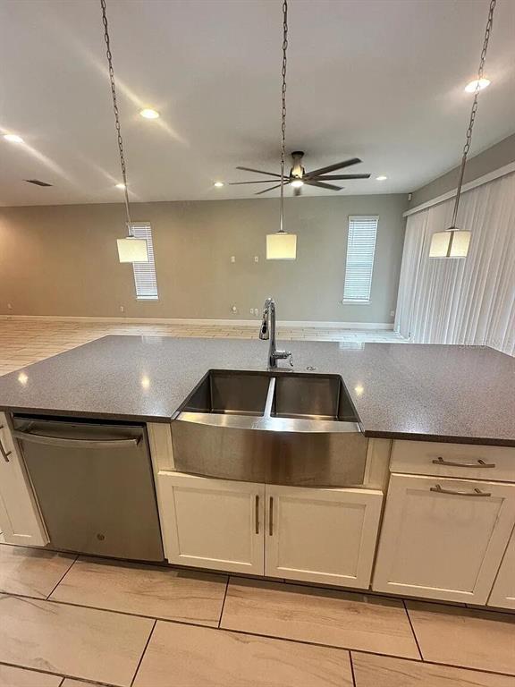 A kitchen island features a stainless steel farmhouse sink, gray countertops, and white cabinets — 534 LAKE WILDMERE COVE, LONGWOOD, FL