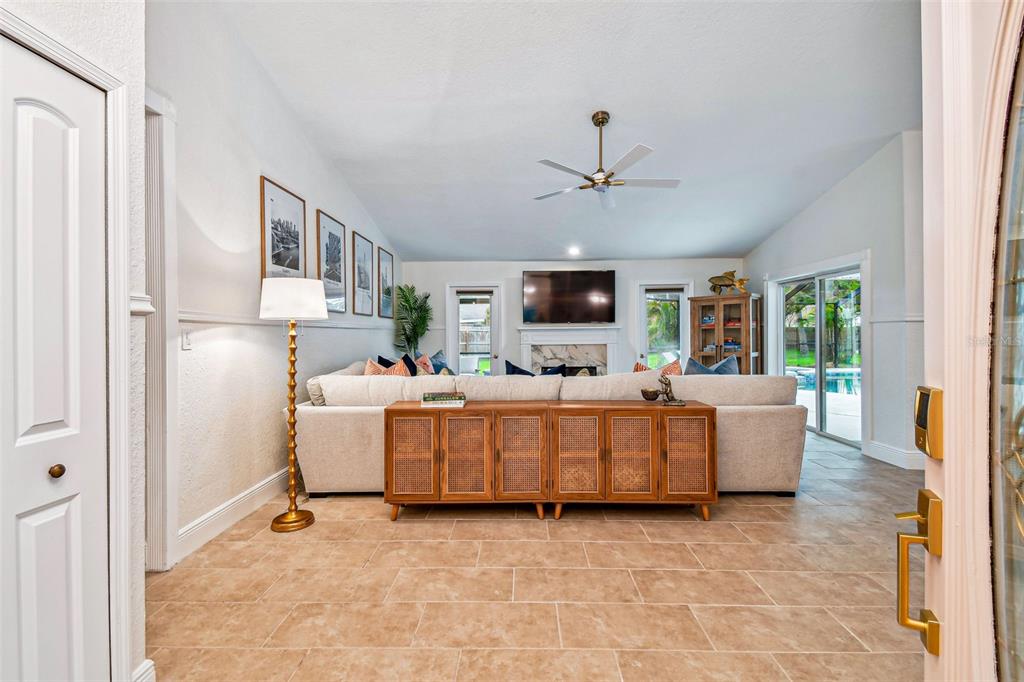 A living room features a large sectional sofa, a wooden console table, and tile flooring — 10503 NILE COURT, TAMPA, FL