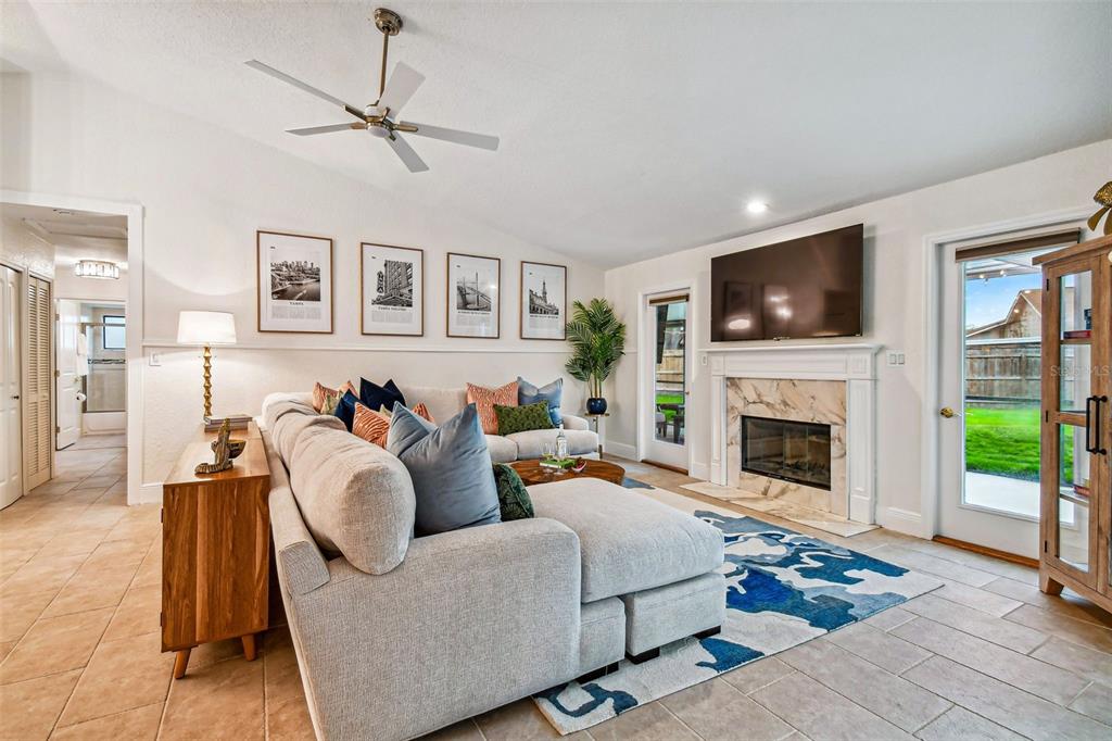 A living room features a sectional sofa, fireplace, television, and tile flooring — 10503 NILE COURT, TAMPA, FL