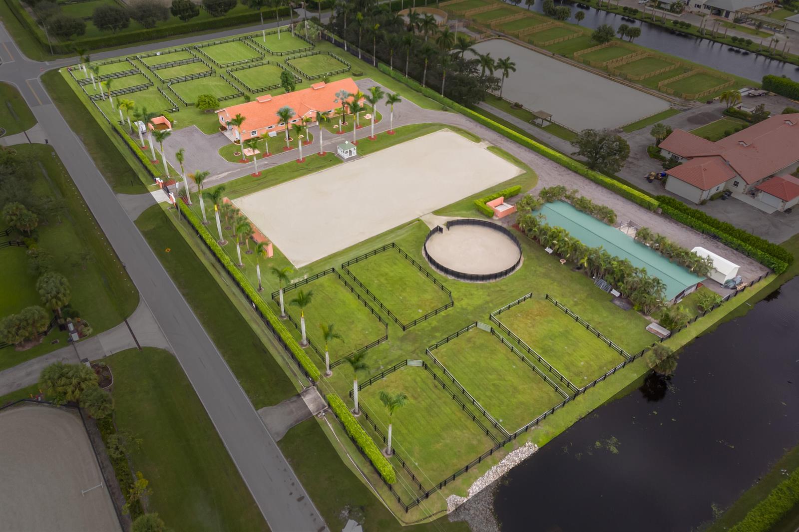 An aerial view shows an equestrian property with a stable, riding arena, and fenced paddocks — 4750 South Road, Wellington FL 33414, WELLINGTON, FL