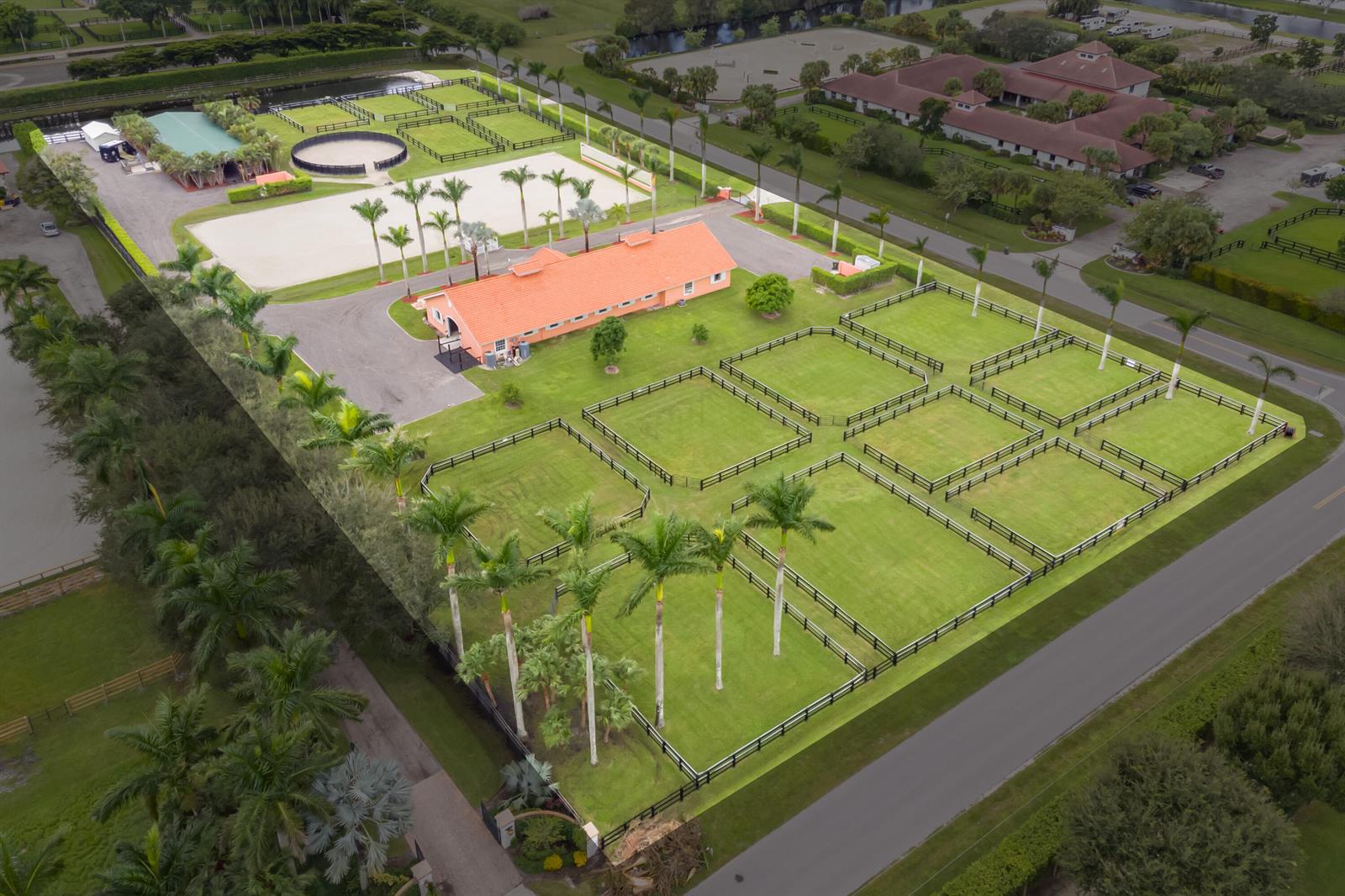 An aerial view of an equestrian property featuring a stable, riding arena, and fenced paddocks — 4750 South Road, Wellington FL 33414, WELLINGTON, FL