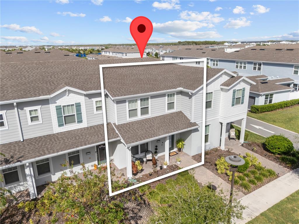 An aerial view shows the exterior of a two-story townhouse with a covered front porch — 14514 ORCHID ISLAND DRIVE, ORLANDO, FL