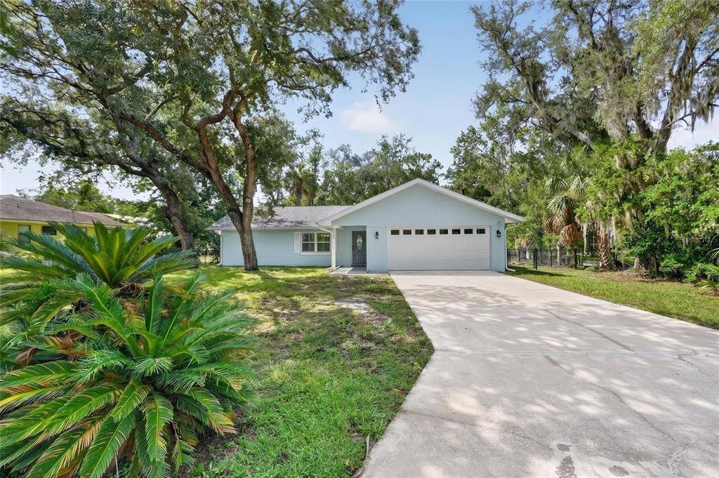 A light blue single-story house with a two-car garage and a concrete driveway — 11108 W THOREAU PLACE, CRYSTAL RIVER, FL