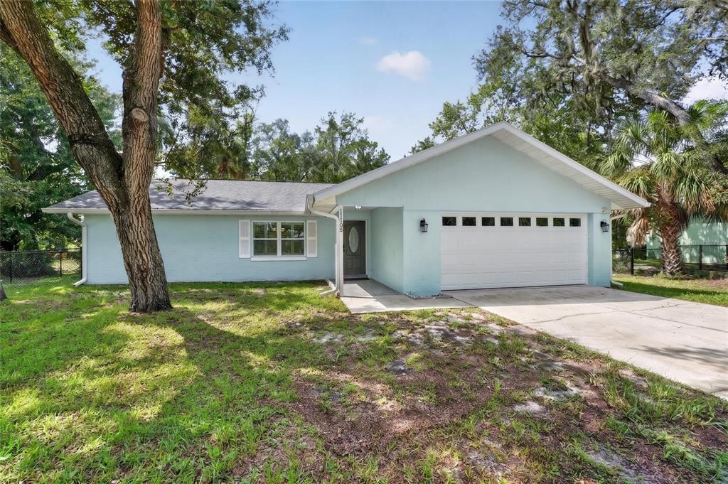 A light blue single-story house with a white garage door and a large front tree — 11108 W THOREAU PLACE, CRYSTAL RIVER, FL