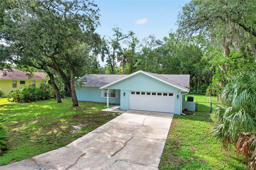 A light blue single-story house with a white garage door and a concrete driveway — 11108 W THOREAU PLACE, CRYSTAL RIVER, FL