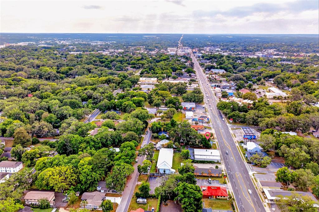 This aerial view shows a commercial property with a red roof along a busy road — 1266 E SILVER SPRINGS BOULEVARD, OCALA, FL