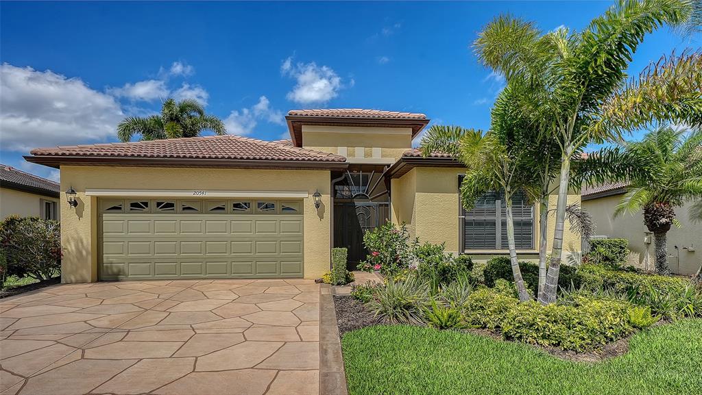 A tiled entryway features a white front door with an oval glass insert and transom window — 20541 CAPELLO DRIVE, VENICE, FL