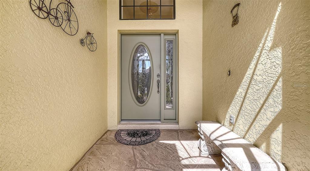A spacious room with light-colored walls, tile flooring, a chandelier, and an arched doorway — 20541 CAPELLO DRIVE, VENICE, FL