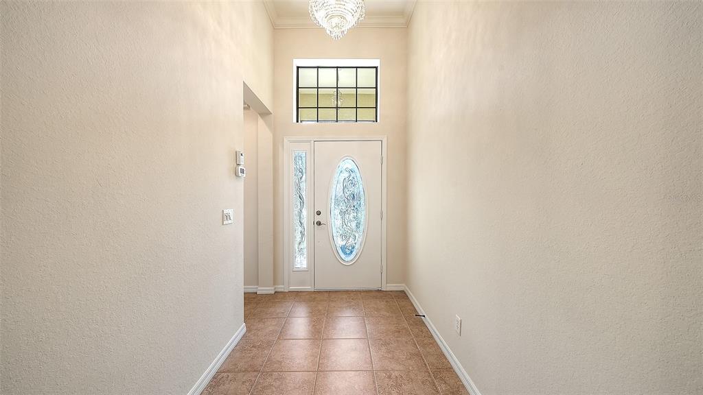 An empty room with beige tile floors, a ceiling fan, and sliding doors to a pool — 20541 CAPELLO DRIVE, VENICE, FL