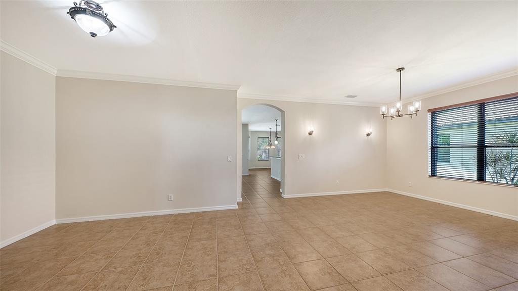 An open-concept kitchen and dining area features tile flooring, dark wood cabinets, and sliding doors — 20541 CAPELLO DRIVE, VENICE, FL