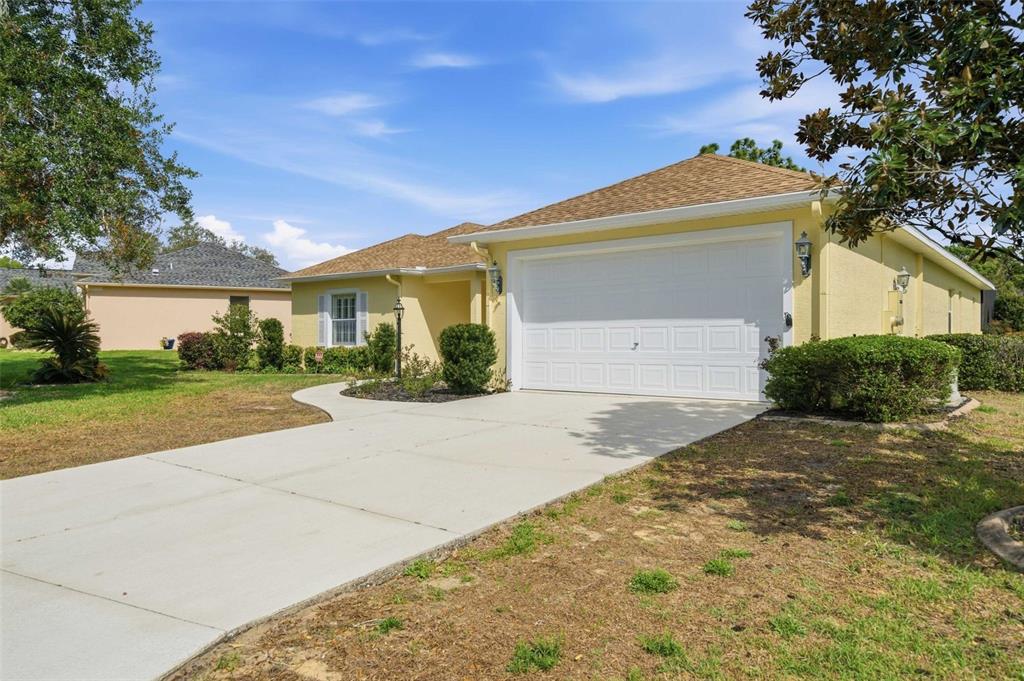 A yellow single-story house with a white garage door and a concrete driveway — 39 W AMALFI COURT, BEVERLY HILLS, FL