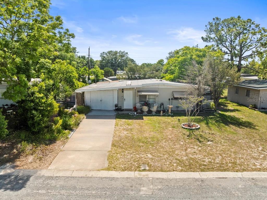 A single-story house with a white exterior, a concrete driveway, and a grassy front yard — 5045 GRAND BOULEVARD, NEW PORT RICHEY, FL
