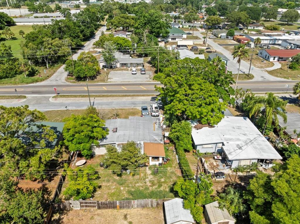 An aerial view shows two adjacent houses with flat roofs and trees on a lot — 5045 GRAND BOULEVARD, NEW PORT RICHEY, FL