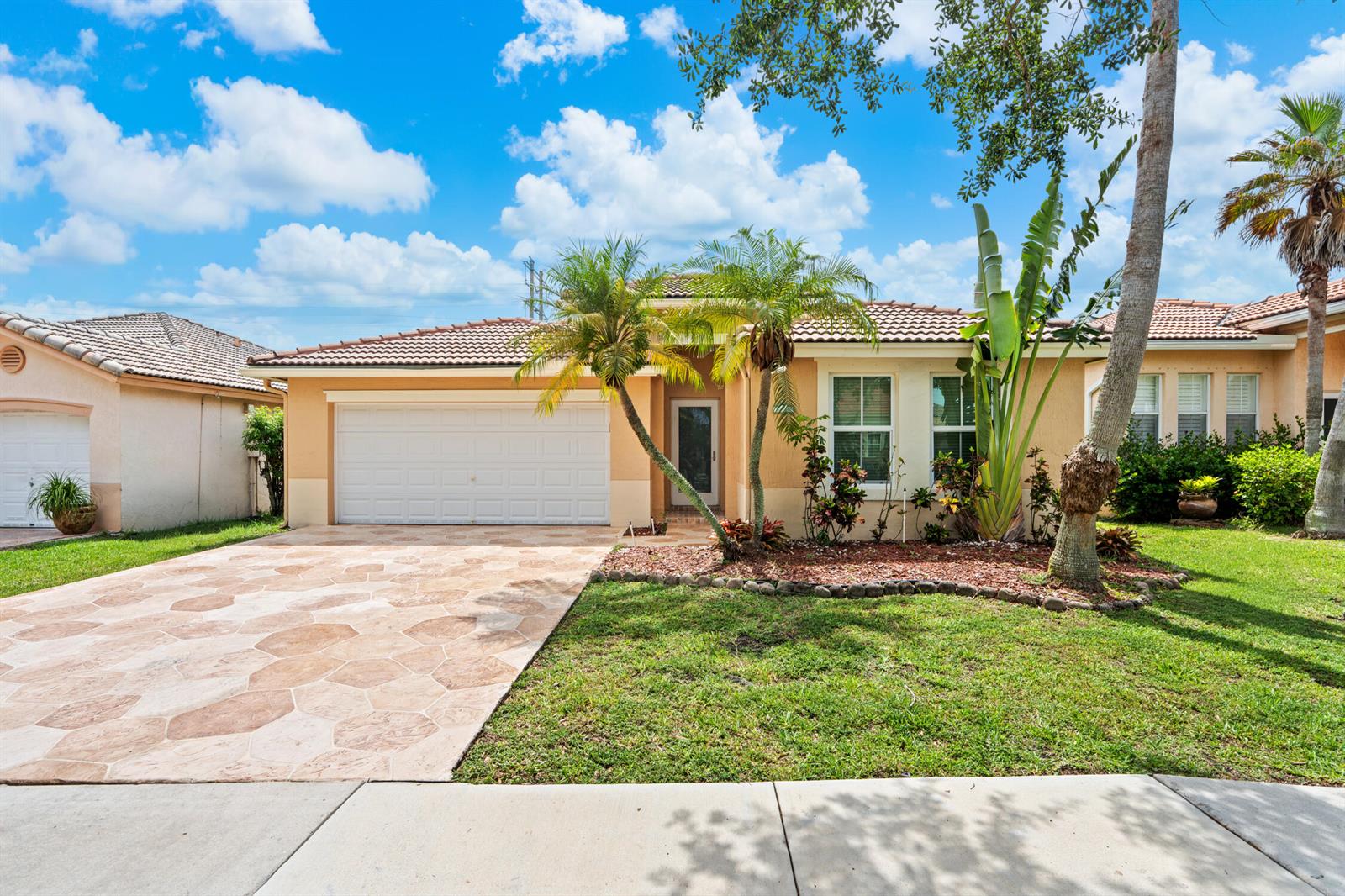A single-story house with a tan stucco exterior, a tiled roof, and a paved driveway — 376 E Royal Cove Circle, Davie FL 33325, DAVIE, FL