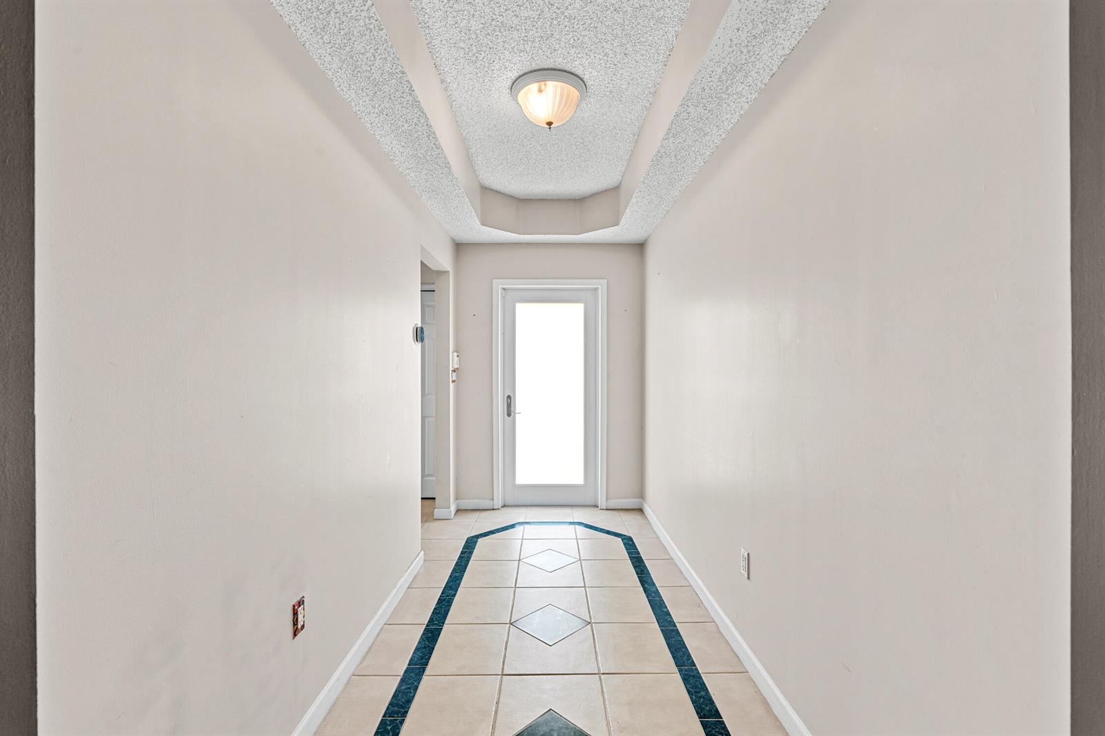 An empty room with beige tile flooring, white walls, and a hanging pendant light fixture — 376 E Royal Cove Circle, Davie FL 33325, DAVIE, FL