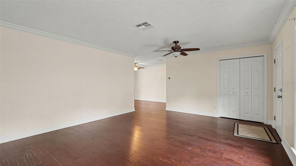 A room with dark wood flooring, white walls, a ceiling fan, and white closet doors — 2434 W GARDENIA DRIVE, CITRUS SPRINGS, FL