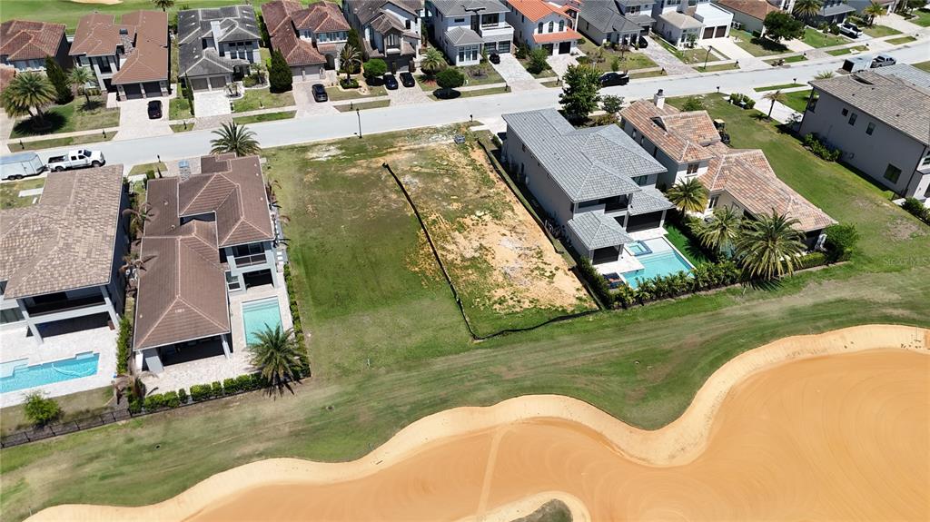 An aerial view shows a vacant residential lot situated between two houses near a golf course — 15954 VETTA DRIVE, MONTVERDE, FL