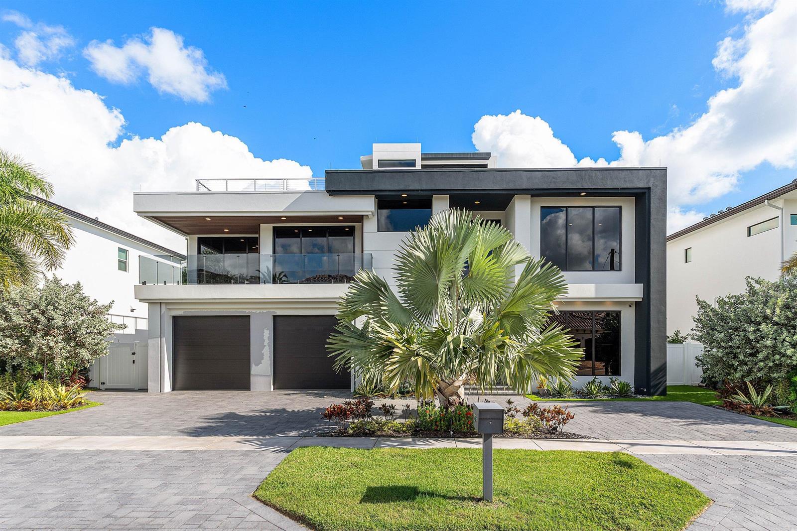 A modern two-story house features a flat roof, a balcony, and a two-car garage — 245 NE 6th Court, Boca Raton FL 33432, BOCA RATON, FL