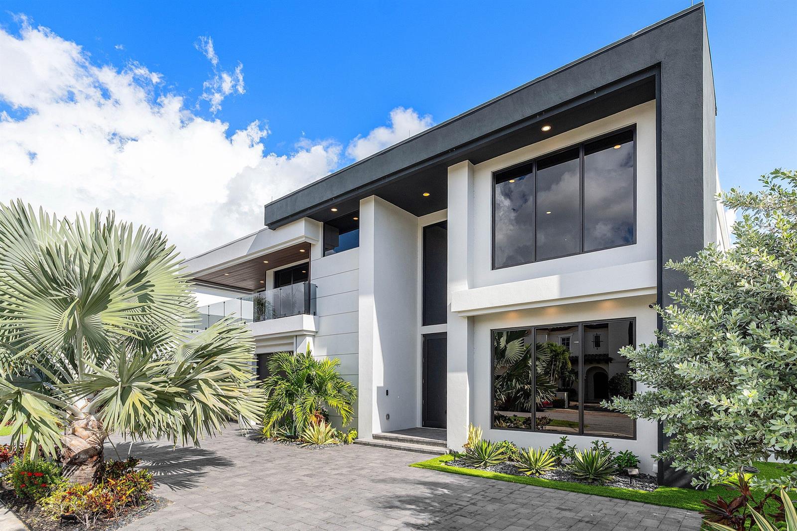 A modern two-story house features a white and dark gray exterior with large glass windows — 245 NE 6th Court, Boca Raton FL 33432, BOCA RATON, FL