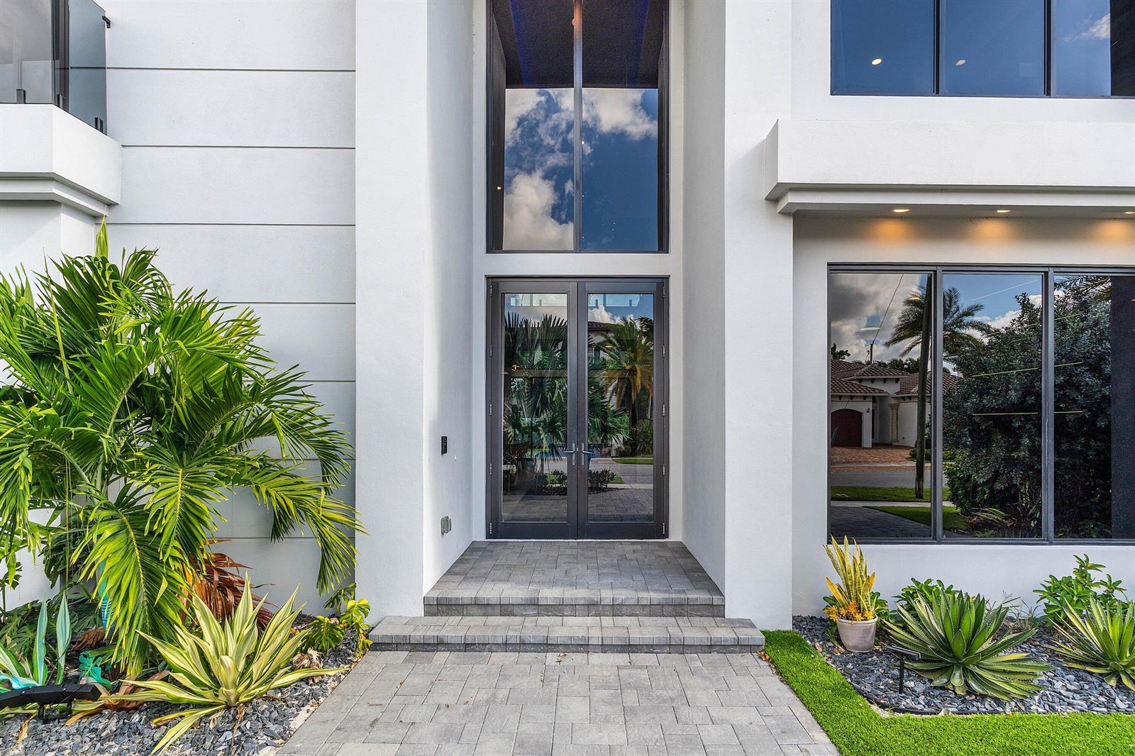 A modern two-story house features a white and dark gray exterior with large glass windows — 245 NE 6th Court, Boca Raton FL 33432, BOCA RATON, FL