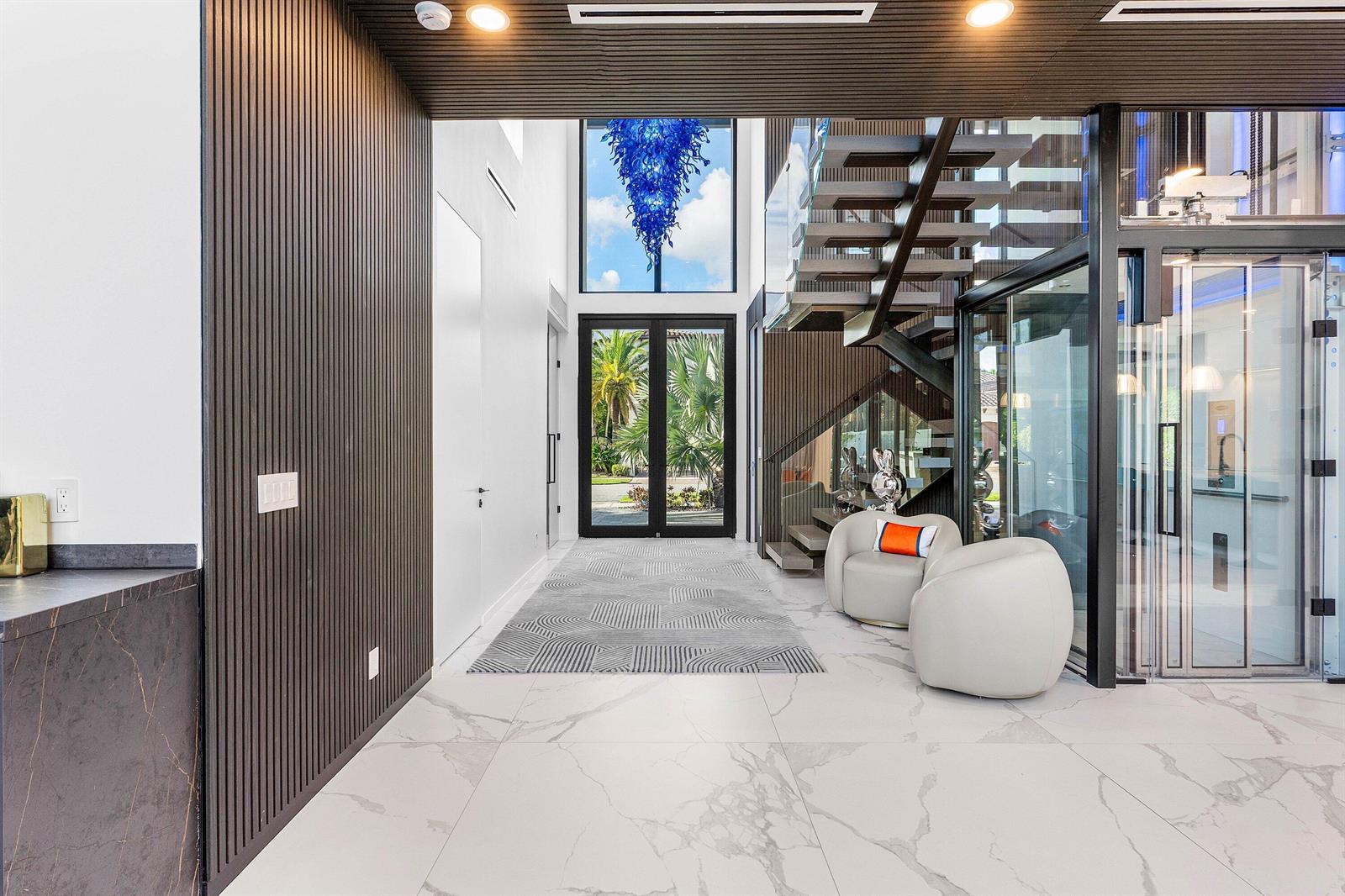 The exterior of a modern white home features a glass double door and stone steps — 245 NE 6th Court, Boca Raton FL 33432, BOCA RATON, FL