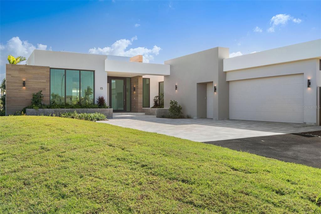 A modern single-story house features a flat roof, wood-look siding, and a two-car garage — 15 THE ISLES AT DORADO BEACH, DORADO, PR