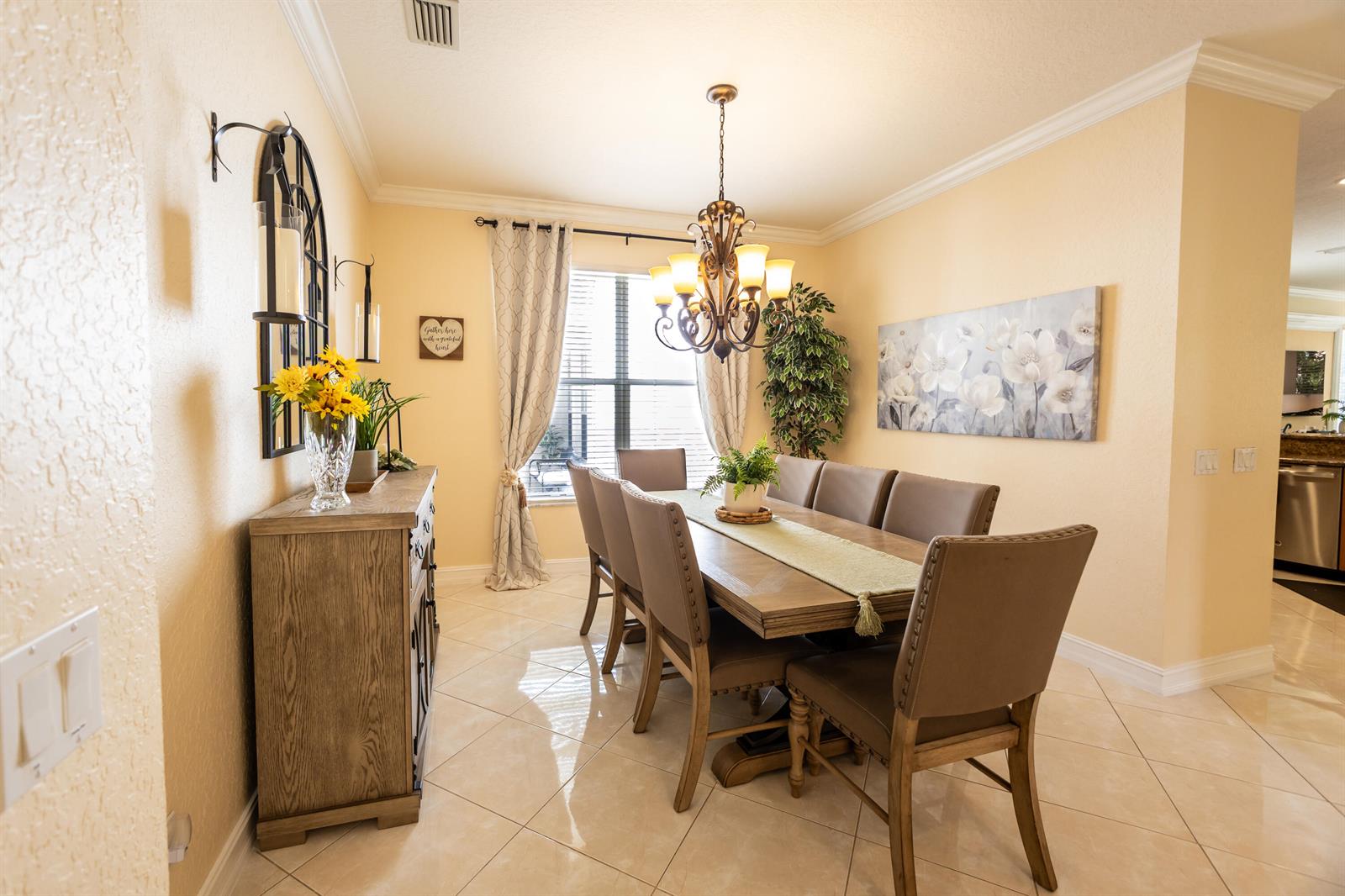 A dining room features a wooden table, upholstered chairs, a chandelier, and a sideboard — 8789 Sandy Crest Lane, Boynton Beach FL 33473, BOYNTON BEACH, FL