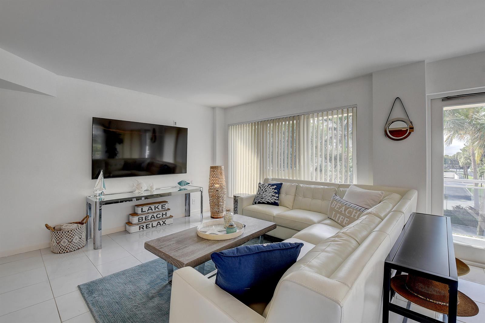 A living room features a white sectional sofa, a glass console table, and a wall-mounted television — 2066 N Ocean Boulevard, Boca Raton FL 33431, BOCA RATON, FL