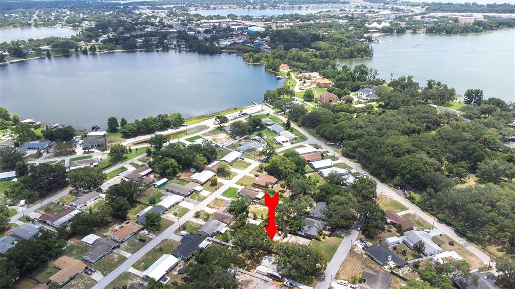 An aerial view shows a residential neighborhood with a red arrow pointing to a house — 144 BEVERLY DR, WINTER HAVEN, FL