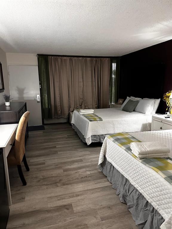 A hotel room features two beds, wood-look flooring, a desk, and floor-to-ceiling curtains — 2050 E IRLO BRONSON MEMORIAL HIGHWAY UNIT 108, KISSIMMEE, FL