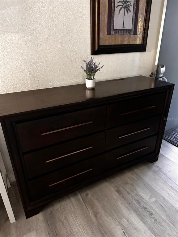 A dark wood dresser with six drawers sits against a wall beneath a framed picture — 2050 E IRLO BRONSON MEMORIAL HIGHWAY UNIT 108, KISSIMMEE, FL