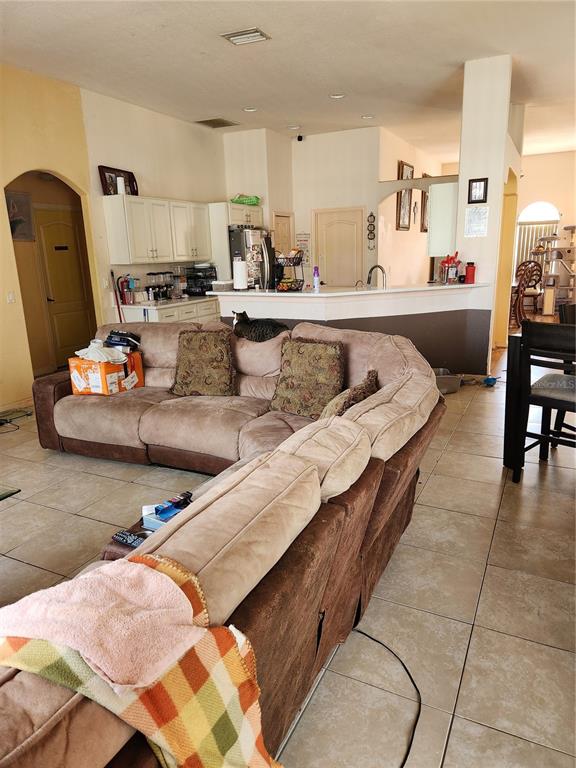 A living room and dining area feature wood-look flooring, a double-door entryway, and arched windows — 4570 MCALLISTER LANE, NORTH PORT, FL