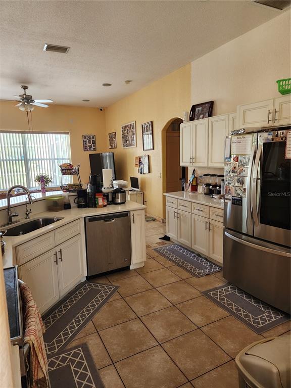 A living room with a large sectional sofa faces an open kitchen with white cabinets — 4570 MCALLISTER LANE, NORTH PORT, FL