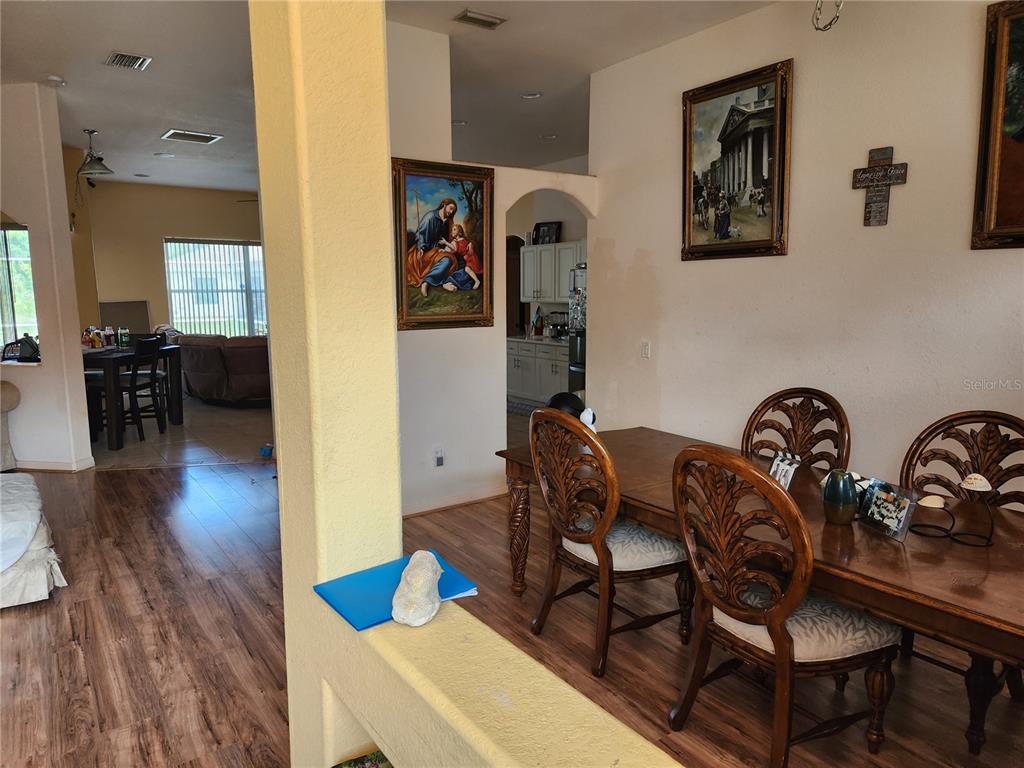 A kitchen features white cabinets, stainless steel appliances, and tan tile flooring — 4570 MCALLISTER LANE, NORTH PORT, FL