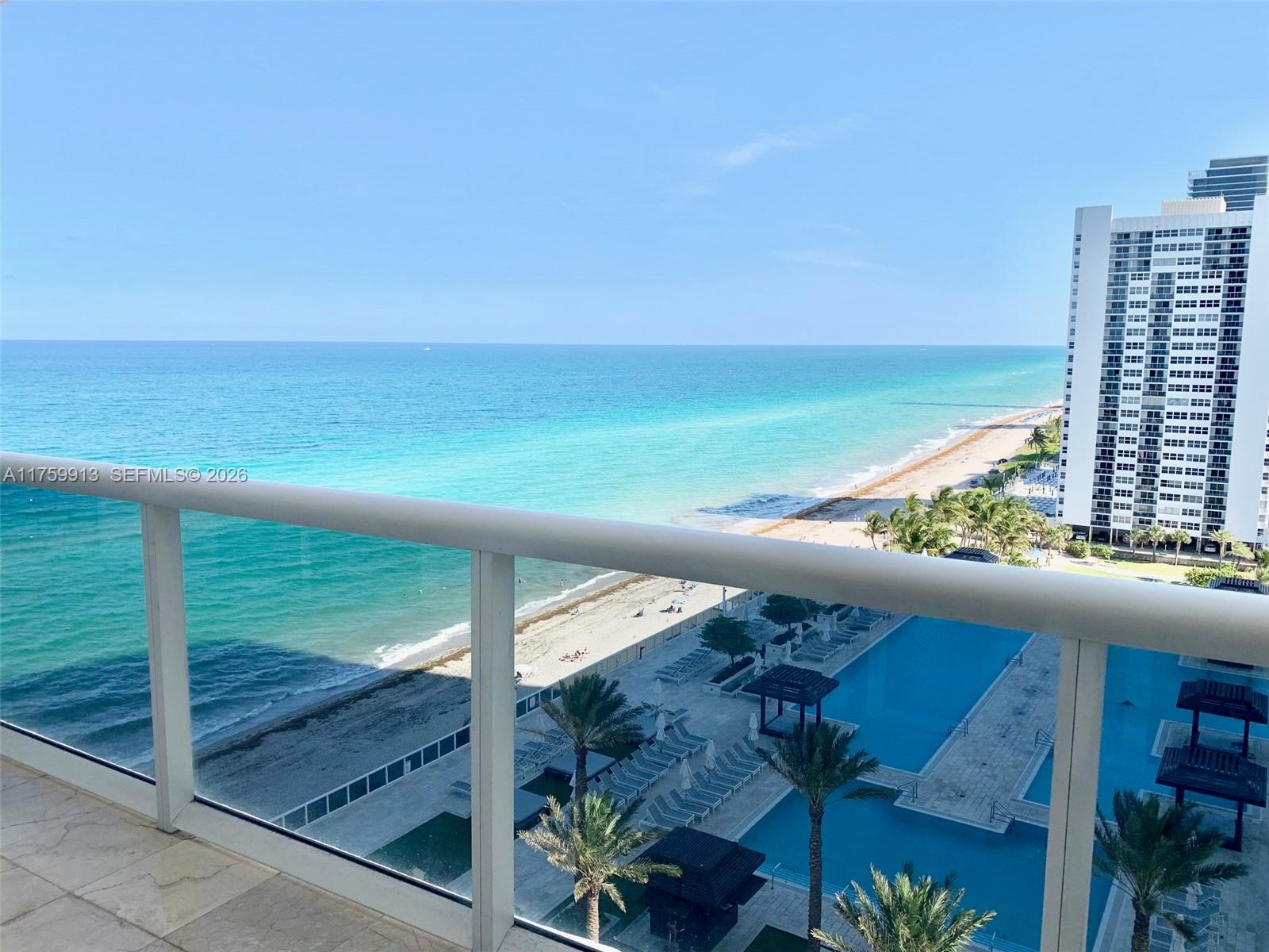 A balcony overlooks a swimming pool, sandy beach, and the ocean — 1830 S Ocean Dr # 1503, Hallandale Beach FL 33009, HALLANDALE BEACH, FL