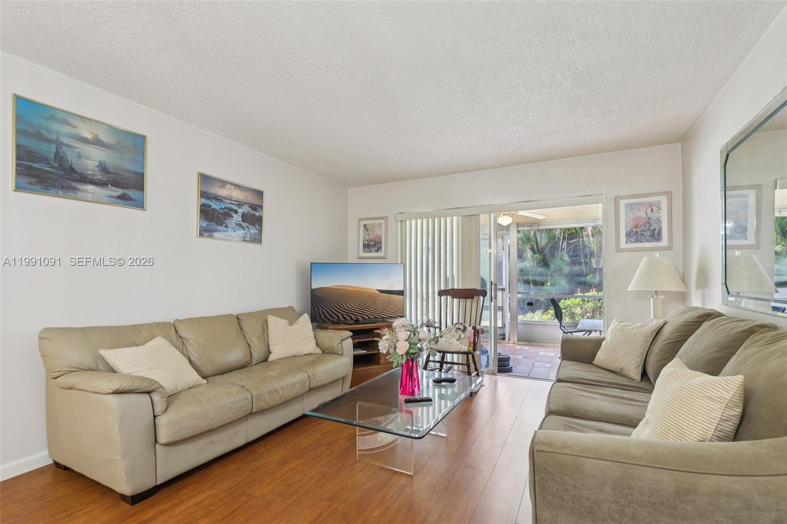 A living room features two leather sofas, a glass coffee table, and a sliding glass door — 3050 N Holiday Springs Blvd # 101, Margate FL 33063, MARGATE, FL