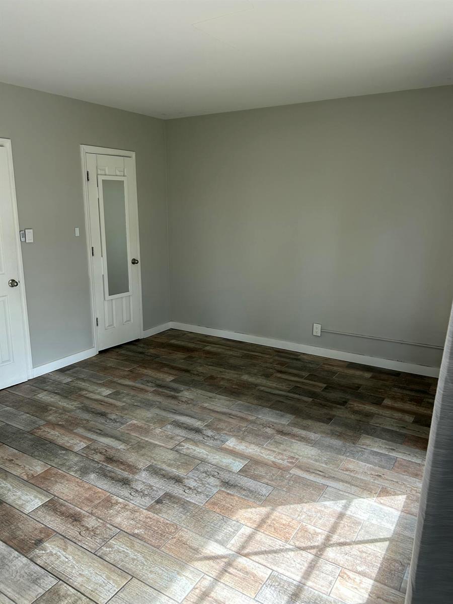 An empty room features gray walls, white trim, and wood-look tile flooring — 214 S Palmway, FL 33460, FL