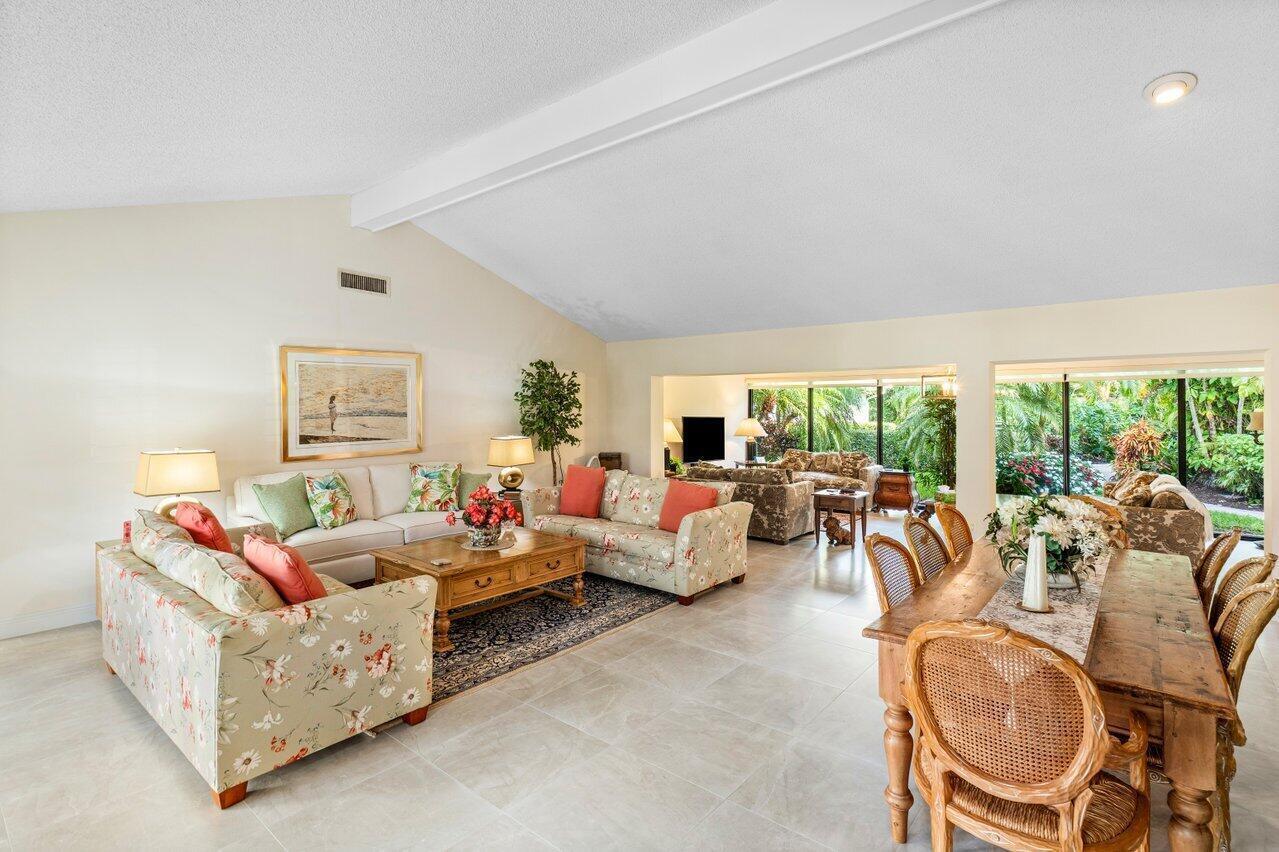 A spacious living and dining area with tile floors, vaulted ceilings, and large glass doors — 4265 Shelldrake Lane, Boynton Beach FL 33436, BOYNTON BEACH, FL
